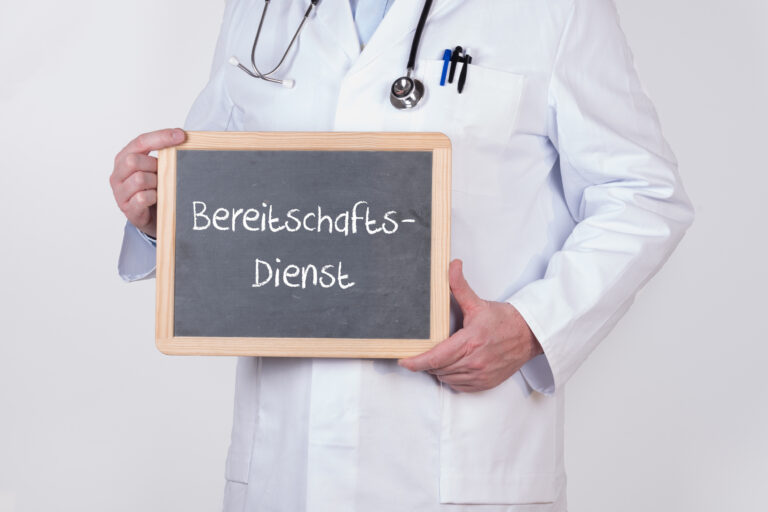 Arzt mit einer Tafel auf der Bereitschaftsdienst steht-mobile